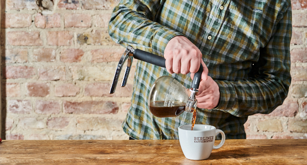 Mann füllt Kaffee in Kaffeetasse von der Berliner Kaffeerösterei